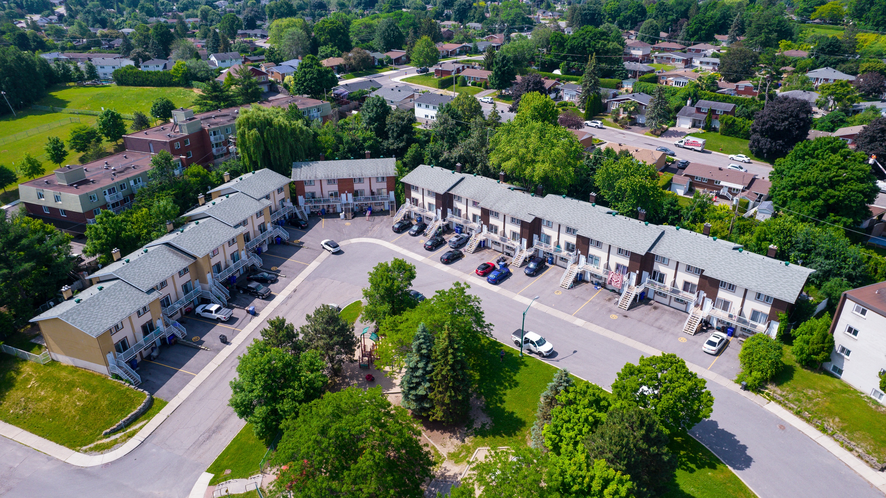 A bird's eye view of a residential area with houses and parked cars.
